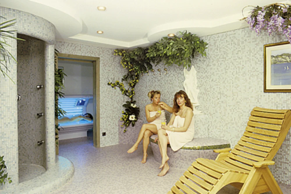 Quiet moments in the Alphotel Tyrol's wellness area: two guests relax in the mosaic-adorned relaxation room — an image of restfulness lived out.